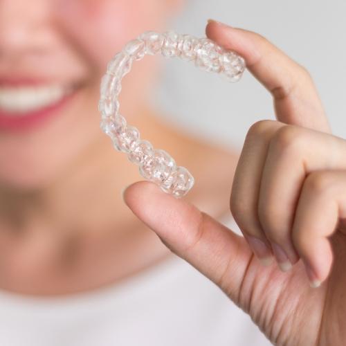 Hand holding a Sure Smile clear braces tray