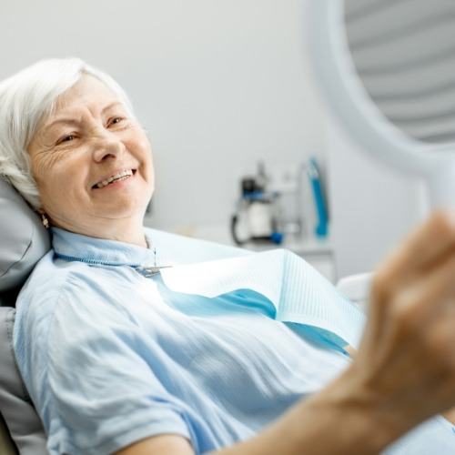 Woman with dental implants looking at her smile