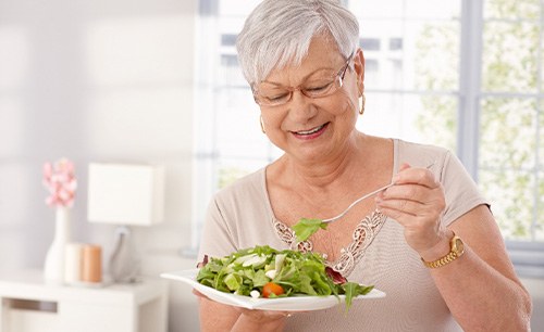 Senior woman with glasses eating a salad