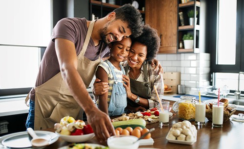 Family cooking healthy foods at kitchen island