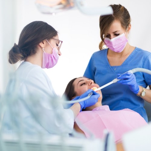 Dental team members treating dentistry patient