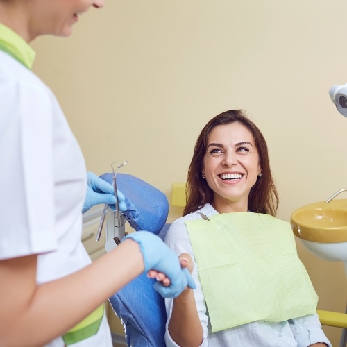 Smiling woman shaking hands with dentist