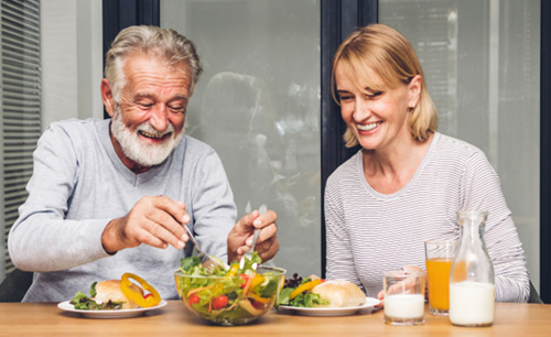 An older couple enjoying a meal of healthy foods