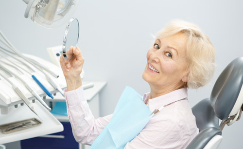 A happy senior woman sitting in a dentist’s chair