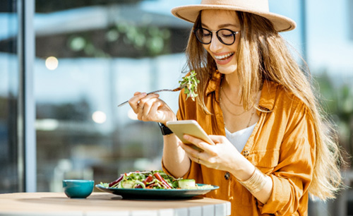 Woman smiling while eating lunch outside