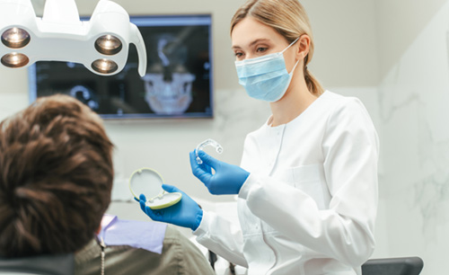 Dentist showing patient clear aligner in treatment room