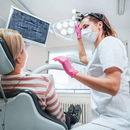 a dentist adjusting a light above a patient’s mouth