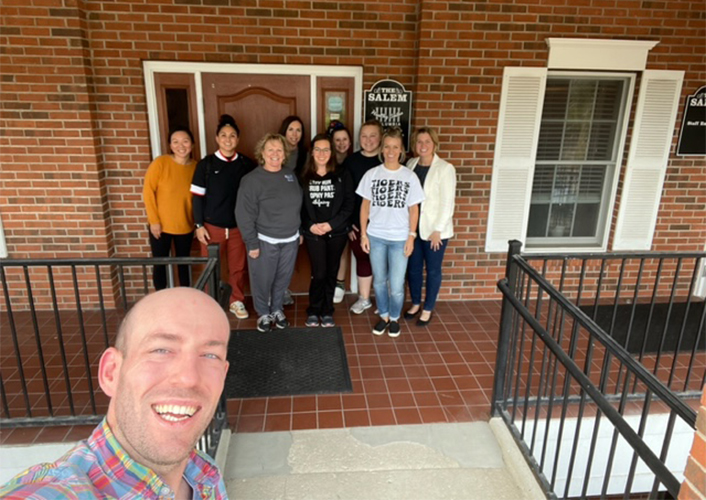 Dentist taking a selfie with dental team members at community event