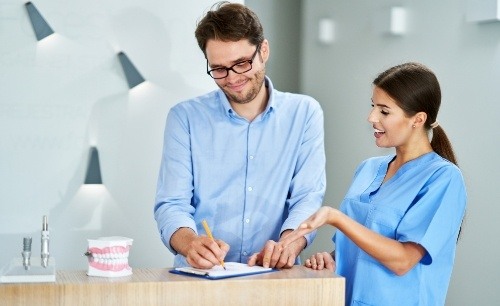 dental team member explaining the cost of dental implants to a patient 