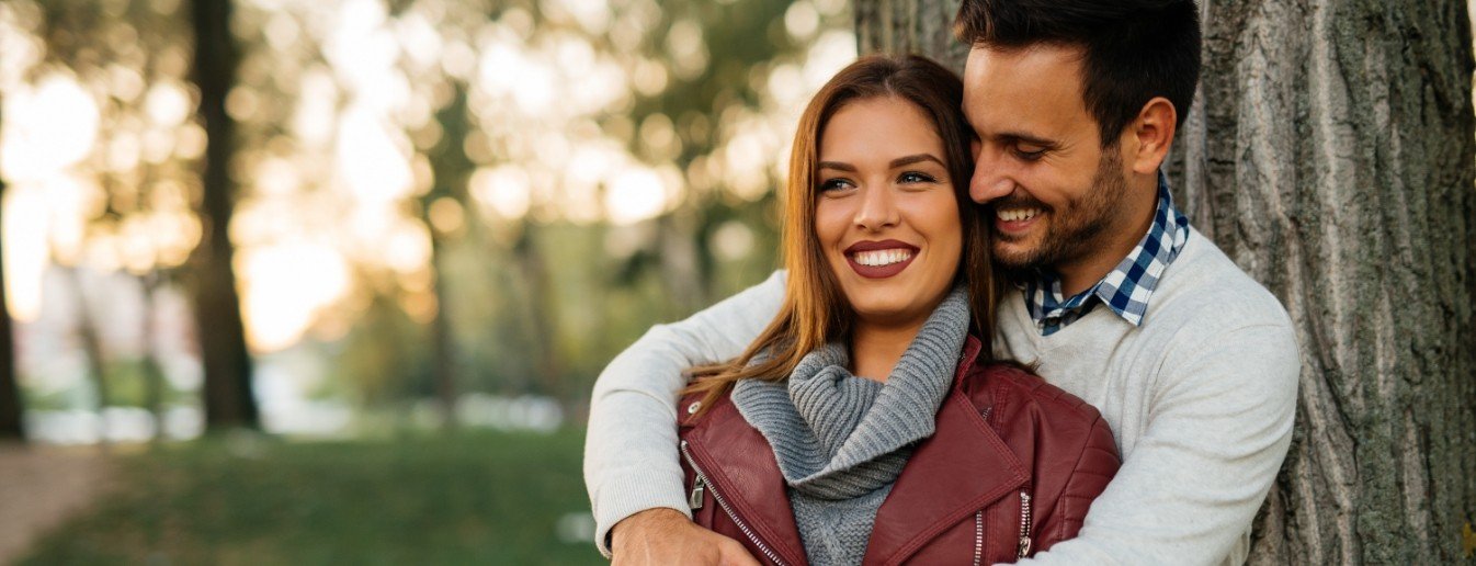 Man and woman smiling together after emergency dentistry