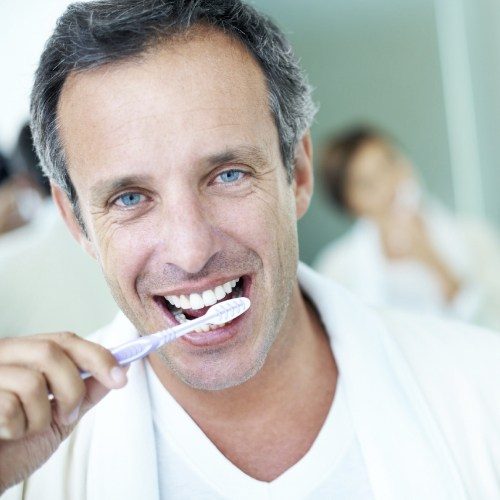 Man brushing teeth to prevent emergency dentistry