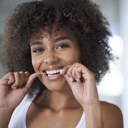 Woman flossing teeth