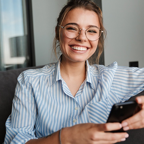 Woman in striped shirt on her phone smiling
