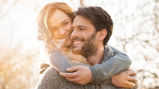 Young man and woman holding each other outdoors