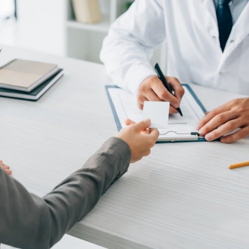 Person handing over their dental insurance card