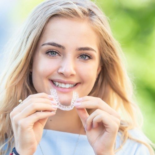 Woman placing Sure Smile clear aligner tray