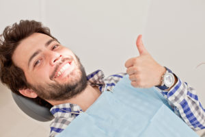 man sitting in dental chair smiling