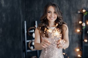 Woman with beautiful smile holding sparklers. 