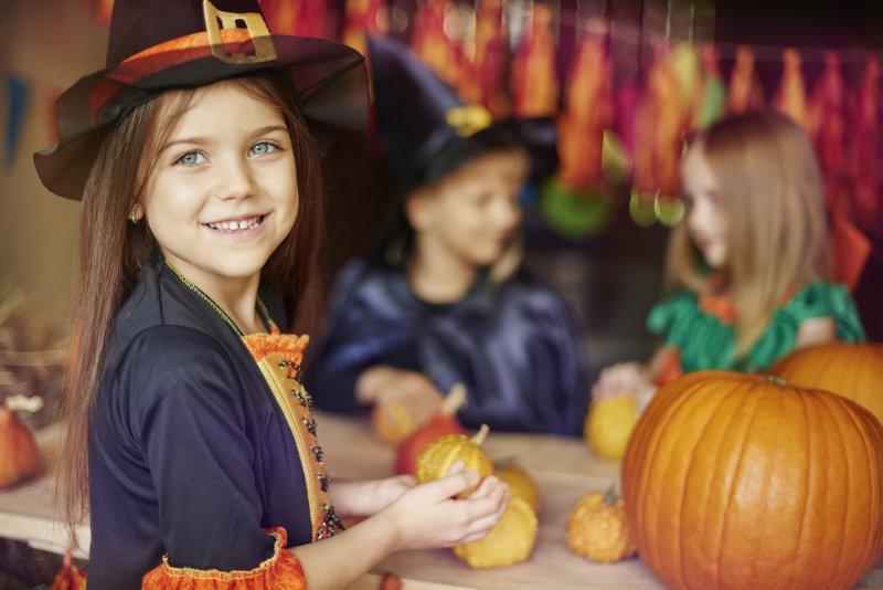 young girl smiling with pumpkins