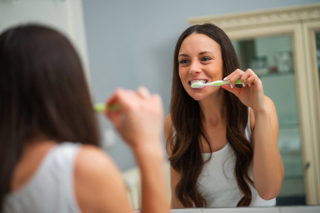 Woman brushing her teeth.