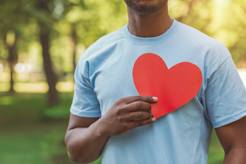 Man holding a red paper heart