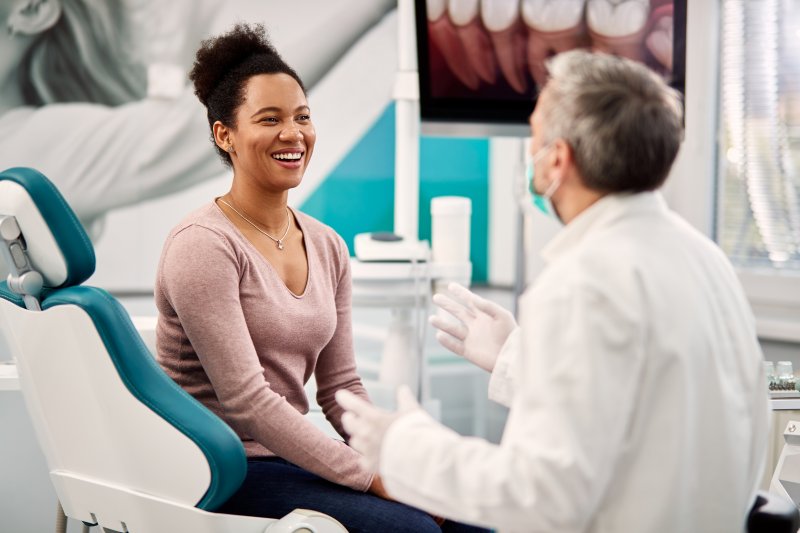 person smiling while talking to dentist