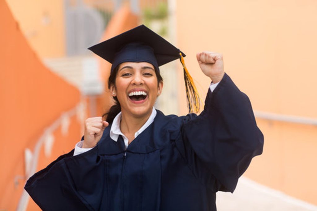 graduating student smiling in cap and gown