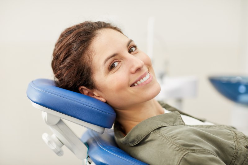 Woman smiling with teeth lying in dental chair