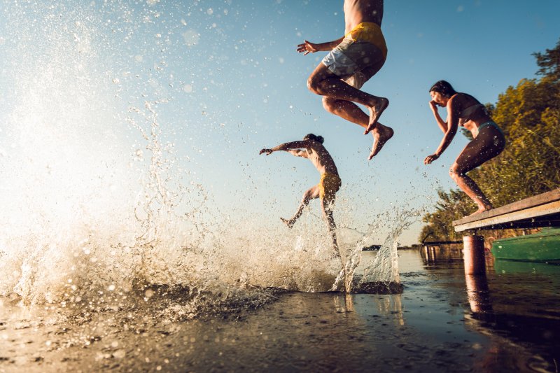 Friends having fun at a lake for summer vacation