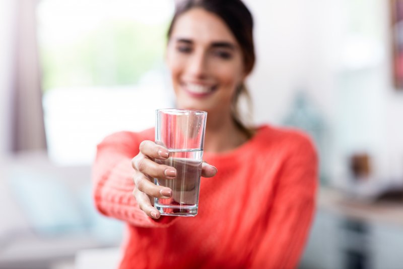 Woman offering you water for your oral health