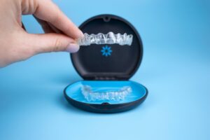 Close-up of hand holding clear aligner.